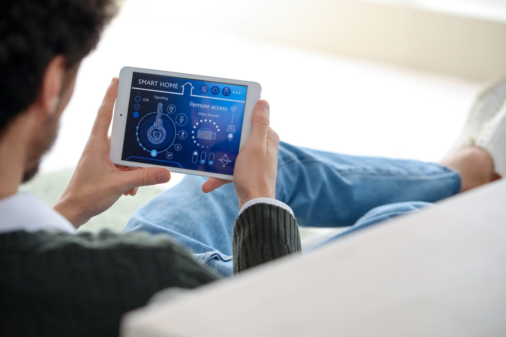 Photo of a Man Using an iPad to View His Unified Home Security System